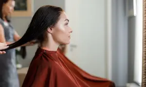 Une femme enceinte choisit une coloration sans ammoniaque pour ses cheveux, une coiffeuse prépare sa chevelure.