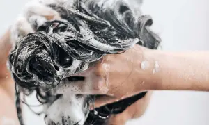Mousse on dark, wet hair as someone is se laver les cheveux au savon de marseille.