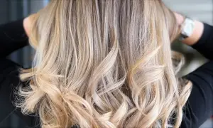Chevelure brune sublimée par des mèches blondes polaires, créant un contraste subtil et lumineux.
