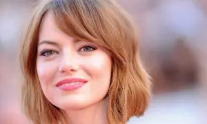 Emma Stone, avec sa coupe de cheveux courte et ondulée, met en valeur son visage rond et ses grands yeux verts.