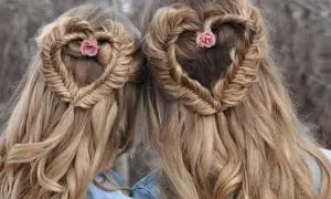 Deux coiffures femme cheveux long en forme de cœur tressé, ornées de petites fleurs roses.