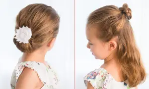 Coiffure élégante pour une tresse enfant fille : un chignon bas orné d'une fleur blanche et une demi-queue tressée.