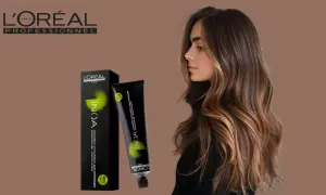 Une femme aux cheveux bruns et blonds, avec une boîte et un tube de coloration INOA L'Oréal. Le temps de pause parfait pour une couleur éclatante.