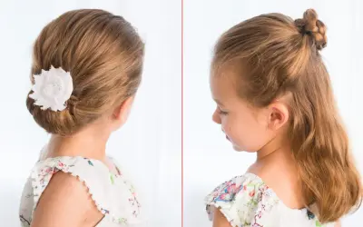 Coiffure élégante pour une tresse enfant fille : un chignon bas orné d'une fleur blanche et une demi-queue tressée.