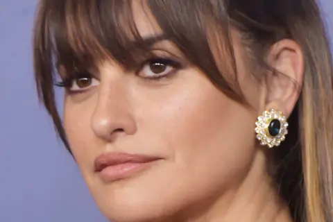 Penelope Cruz, radieuse avec sa coupe qui rajeunit, porte une boucle d'oreille ornée de diamants et d'une pierre bleue.