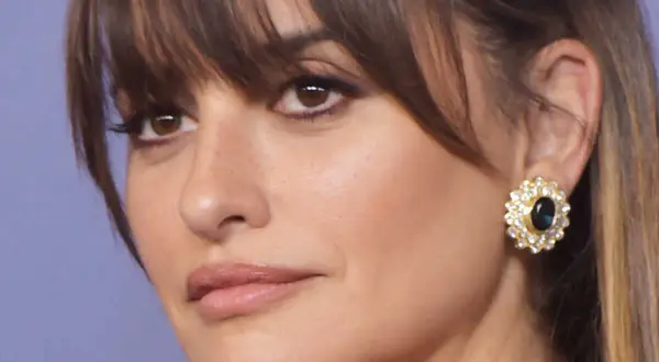 Penelope Cruz, radieuse avec sa coupe qui rajeunit, porte une boucle d'oreille ornée de diamants et d'une pierre bleue.
