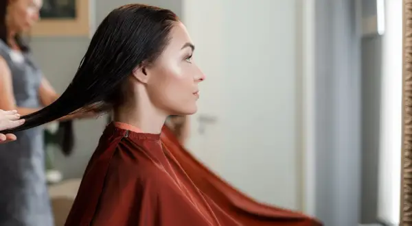 Une femme enceinte choisit une coloration sans ammoniaque pour ses cheveux, une coiffeuse prépare sa chevelure.