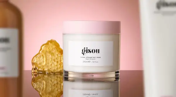 Masque cheveux Gisou infusé au miel, à utiliser avant ou après le shampoing, avec un morceau de nid d'abeille.