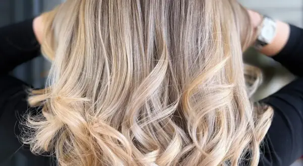 Chevelure brune sublimée par des mèches blondes polaires, créant un contraste subtil et lumineux.