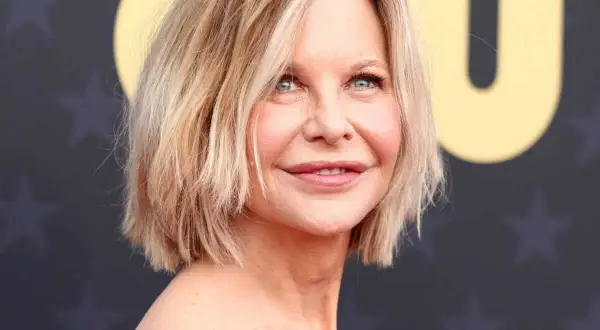 Une femme de 50 ans avec une coupe courte et dégradée, parfaite pour des cheveux fins et plats, rayonne sur le tapis rouge.