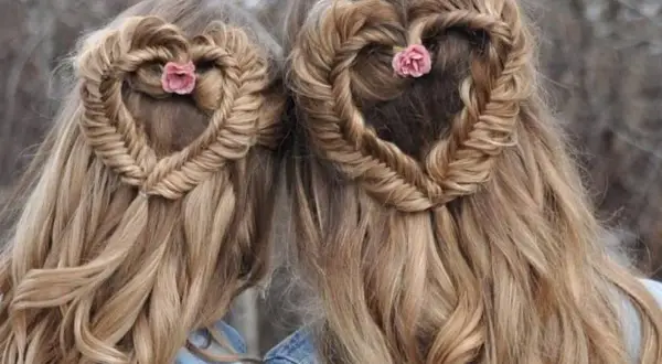 Deux coiffures femme cheveux long en forme de cœur tressé, ornées de petites fleurs roses.