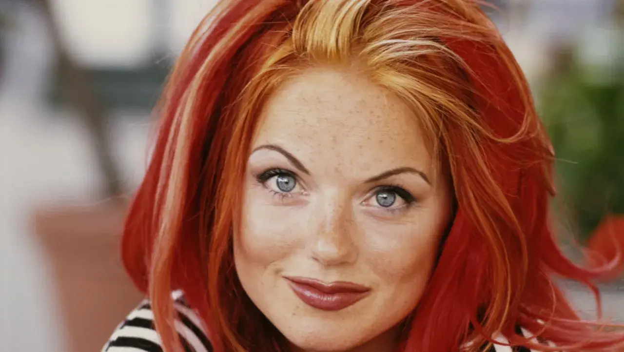 Un portrait de Geri Halliwell, ses cheveux roux flamboyants contrastent avec deux mèches blondes devant.