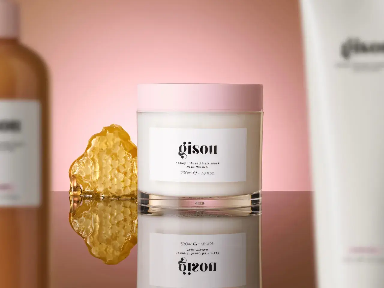 Masque cheveux Gisou infusé au miel, à utiliser avant ou après le shampoing, avec un morceau de nid d'abeille.