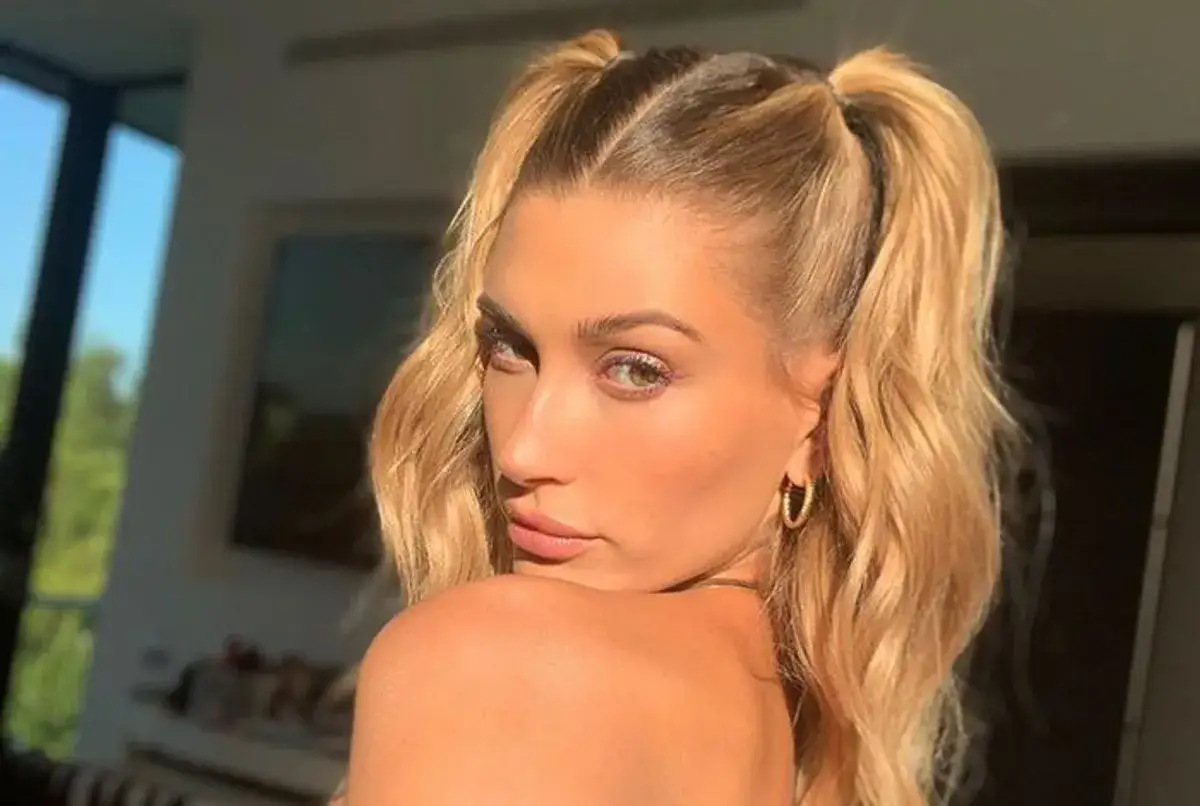 Une jeune femme aux cheveux blonds porte des couettes hautes, un style ludique et tendance.