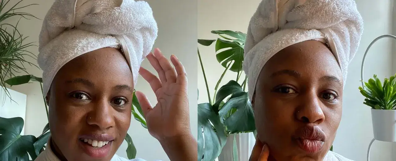 Femme avec serviette sur la tête, pose pour la caméra. Elle se demande combien de temps laisser poser un masque cheveux pour un soin optimal.