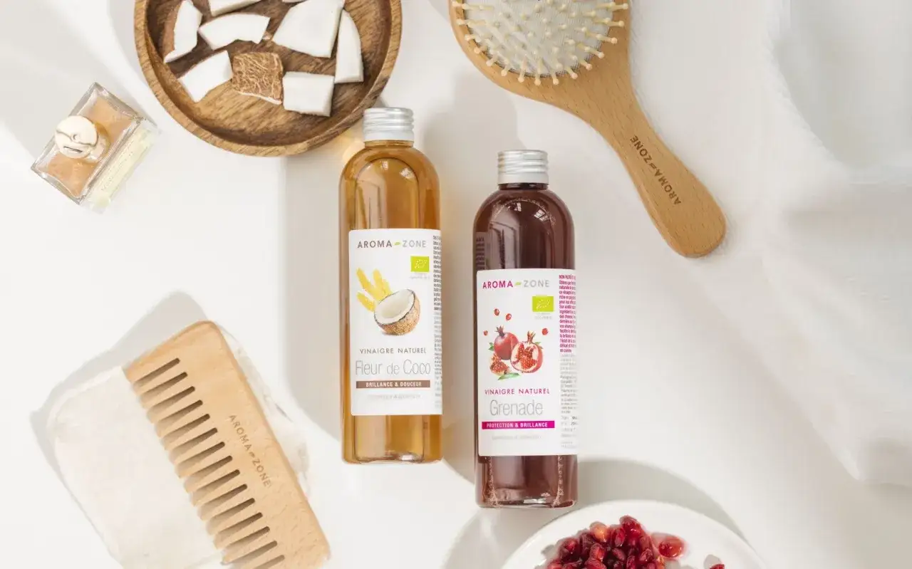 Comment avoir des cheveux brillant et soyeux naturellement : vinaigres de coco et grenade Aroma-Zone, peignes en bois, noix de coco et grenade.