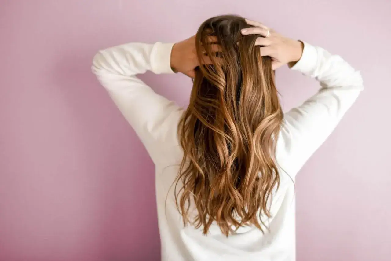 Chevelure brune avec des reflets blonds subtils, une coloration claire sur cheveux foncés sans décoloration.
