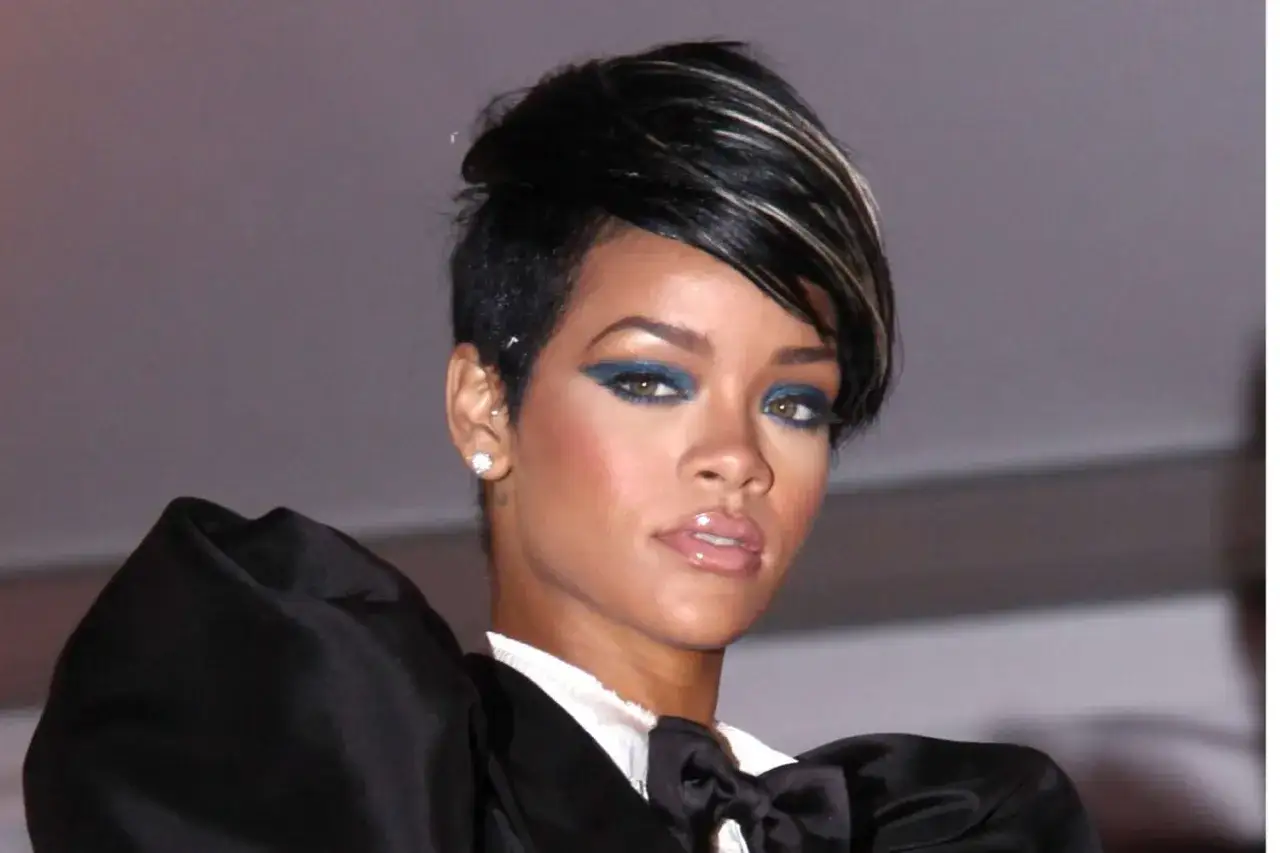 Rihanna arbore une coupe pixie ras&eacute;e audacieuse, rehauss&eacute;e d'un maquillage bleu &eacute;lectrique et d'une tenue noire spectaculaire.