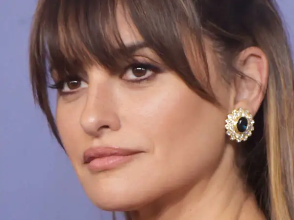 Penelope Cruz, radieuse avec sa coupe qui rajeunit, porte une boucle d'oreille ornée de diamants et d'une pierre bleue.