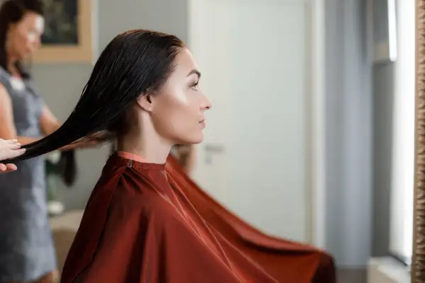 Une femme enceinte choisit une coloration sans ammoniaque pour ses cheveux, une coiffeuse prépare sa chevelure.